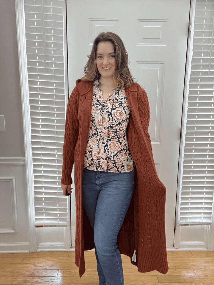 Crystal in a long rust-colored cardigan and orange and navy print shirt from Nuuly